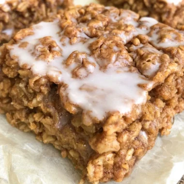 Healthy cinnamon roll baked oatmeal in a dish, topped with cinnamon and nuts.