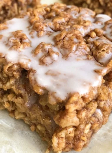 Healthy cinnamon roll baked oatmeal in a dish, topped with cinnamon and nuts.